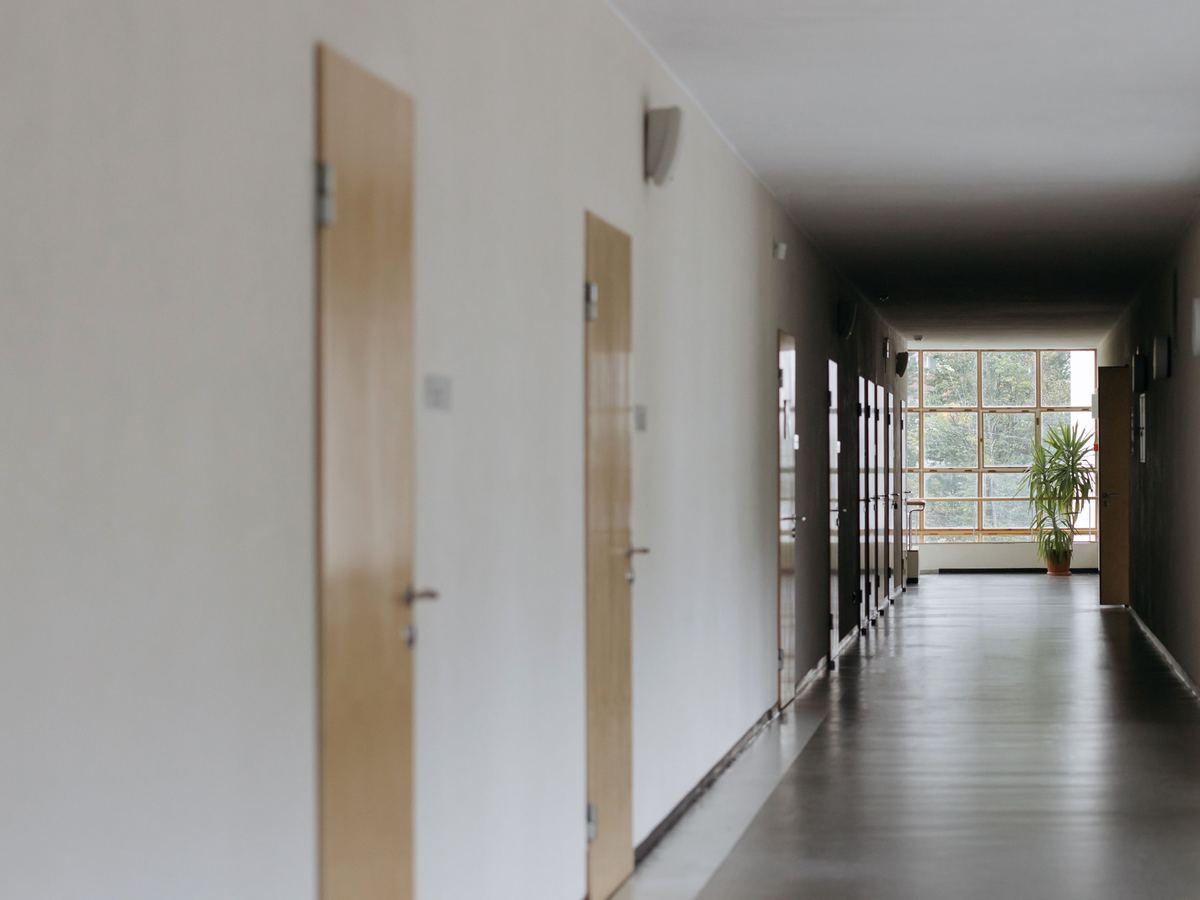 A quiet hallway of closed interior doors in a public building